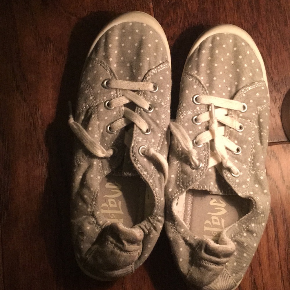 Gray and white polka dot slip on shoes.